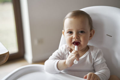 Close-up of cute girl eating food at home