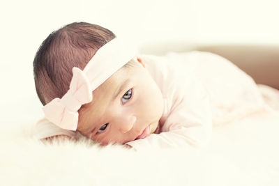 Portrait of cute baby lying on bed at home