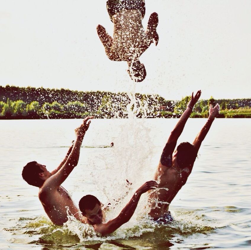 water, leisure activity, lifestyles, full length, jumping, nature, holding, fun, day, men, sky, waterfront, lake, outdoors, enjoyment, mid-air, tree, balance