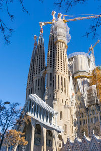 Low angle view of sagrada familia against clear blue sky