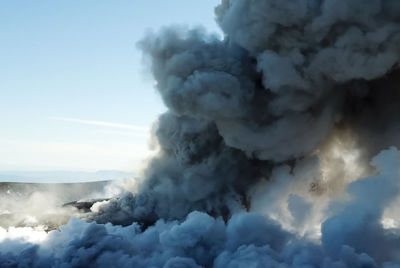 Smoke emitting from volcanic mountain against sky