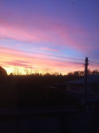 Silhouette trees against dramatic sky during sunset