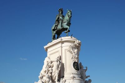 Low angle view of statue against blue sky