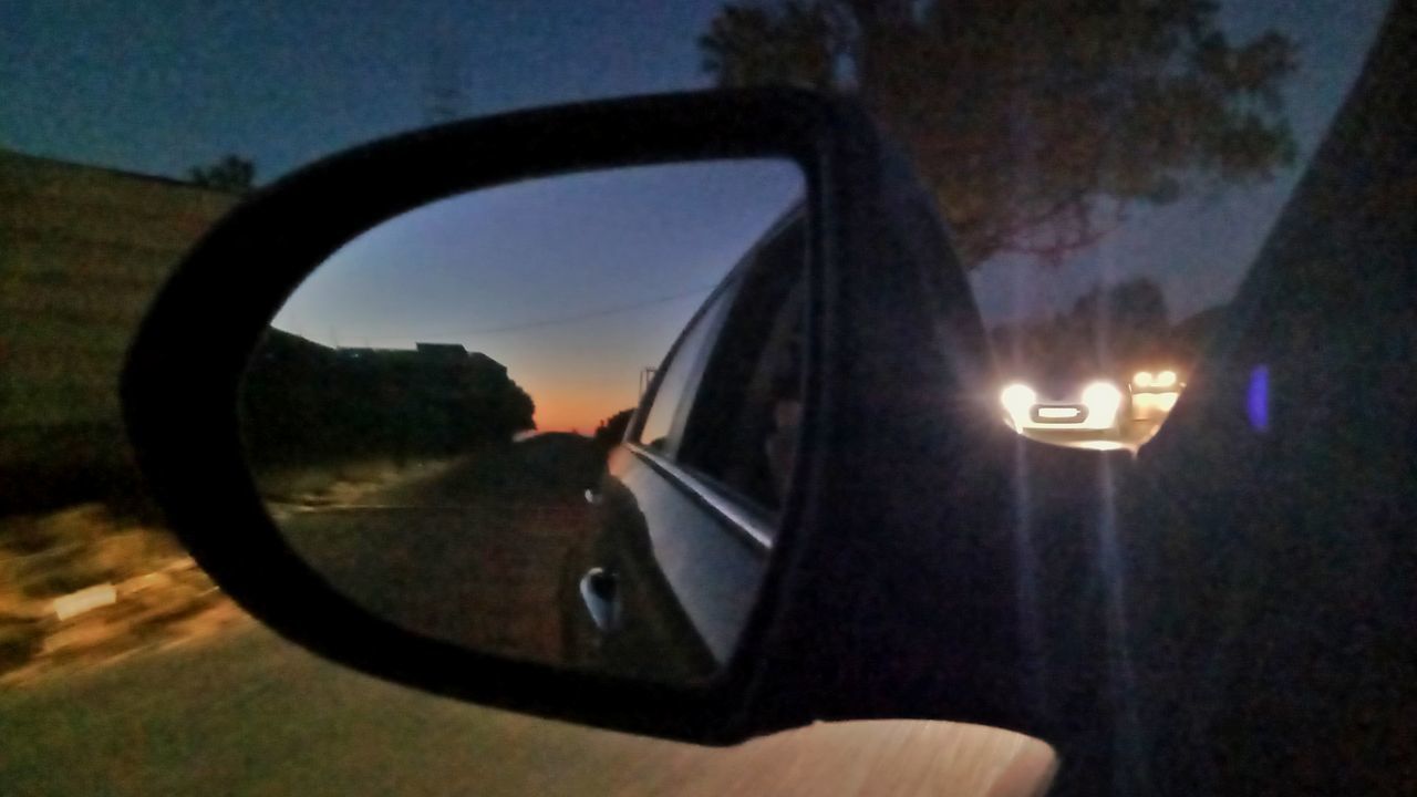 REFLECTION OF CAR ON SIDE-VIEW MIRROR OF VEHICLE