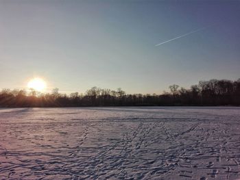 Scenic view of snow covered field against sky