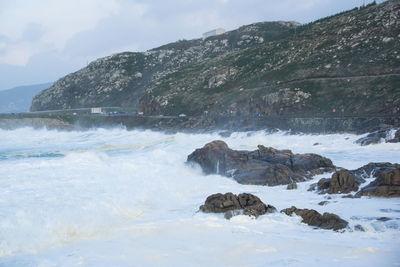 Rocks in sea against sky