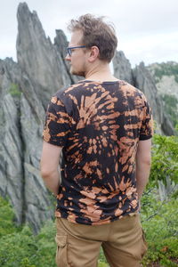 Rear view of man standing against rock formation