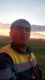 Portrait of man on field against sky during sunset