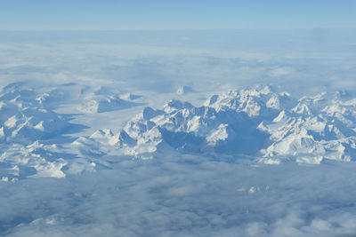 Aerial view of snow covered mountains against sky