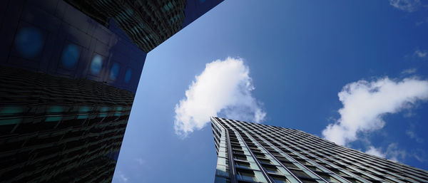 Low angle view of modern building against blue sky