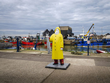 Yellow standing by harbor against sky