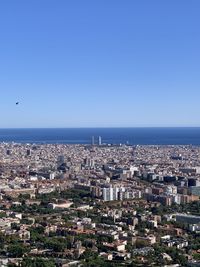 Aerial view of buildings and sea against clear sky