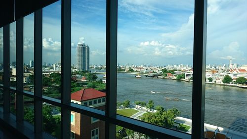 Modern cityscape against sky seen through window