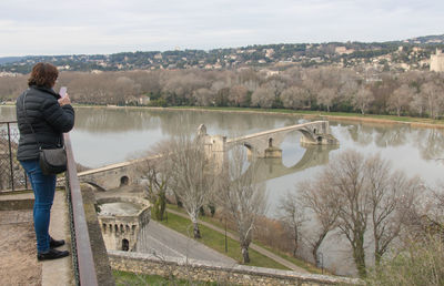 Woman photographing bridge of avignon