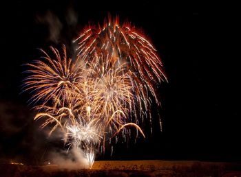 Low angle view of firework display at night