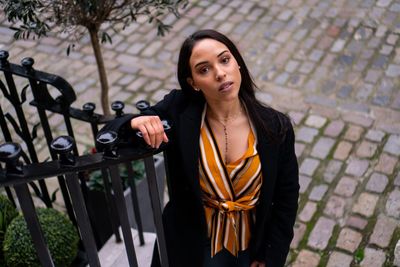 Portrait of woman standing against railing