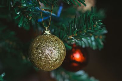 Golden christmas ball. golden glitter. close-up of christmas decoration hanging on tree