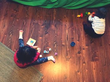 High angle view of friends sitting on wooden floor