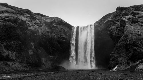 Scenic view of waterfall against sky