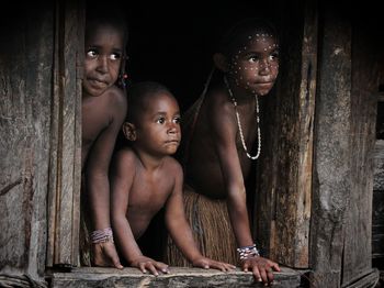 Portrait of father and son sitting on wood