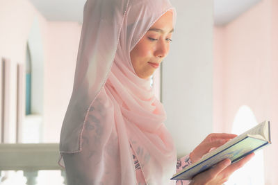 Side view of woman praying at mosque