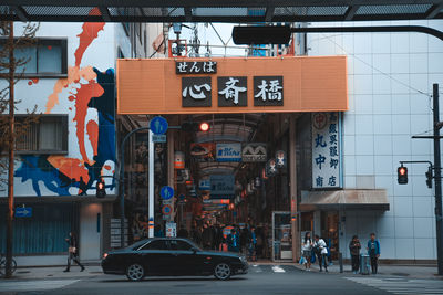 People on road against buildings in city