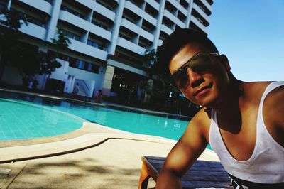 Portrait of man wearing sunglasses by swimming pool