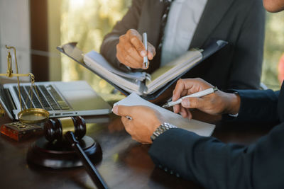 Midsection of business colleagues working on table