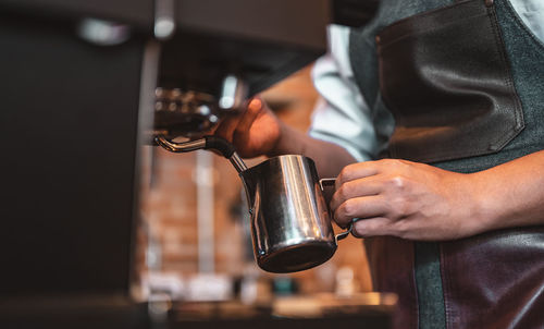 Midsection of barista working in cafe