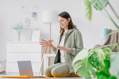 Young woman using digital tablet while standing in office