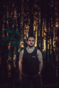 Portrait of young man standing in forest