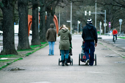 Rear view of people walking on road