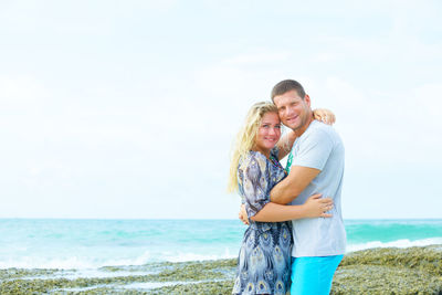 Portrait of a happy couple in love on the beach at summer day