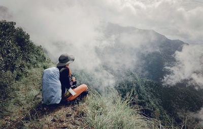 Rear view of men sitting on mountain