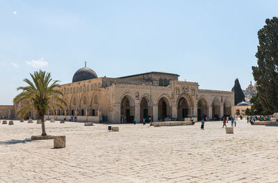 Group of people in front of historic building against sky