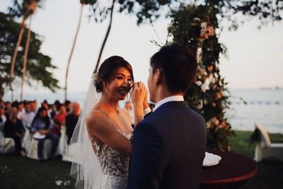 Rear view of couple kissing against sky