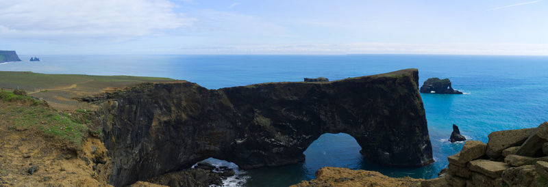 Scenic view of rocks on sea against sky