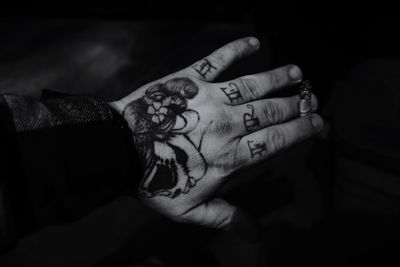 Cropped image of tattooed hand holding burnt cigarette