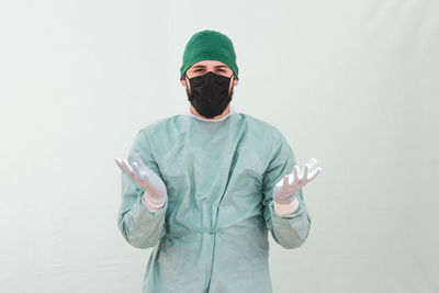 Man holding umbrella while standing against white background