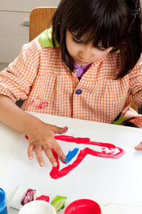 High angle view of girl sitting on table