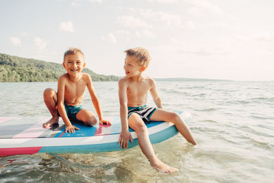 Full length of happy friends on beach against sea