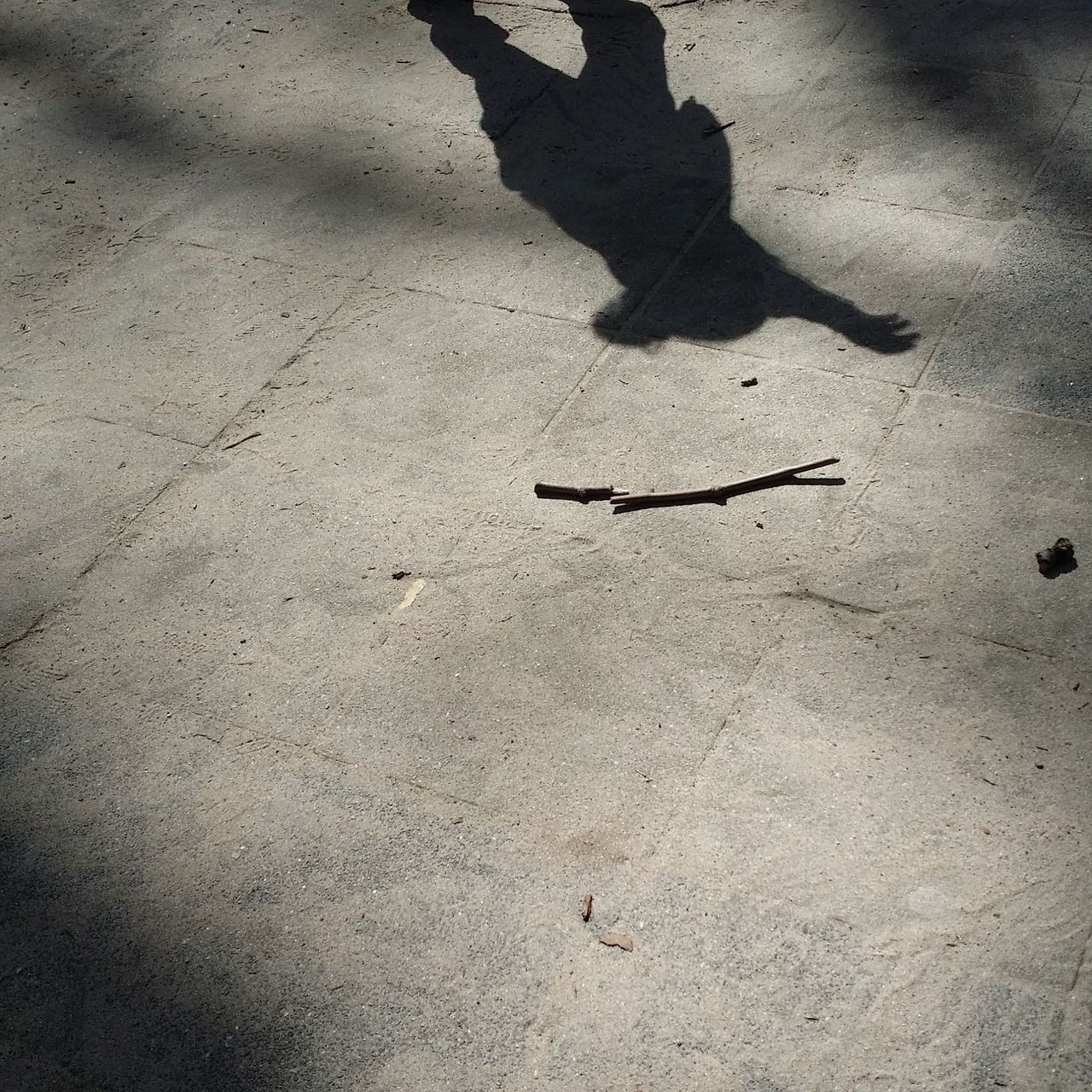 high angle view, shadow, sunlight, focus on shadow, street, lifestyles, asphalt, leisure activity, unrecognizable person, road, outdoors, day, sand, men, low section, ground, standing, textured