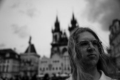 Portrait of young woman looking away against sky