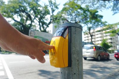 Hand holding yellow car on street