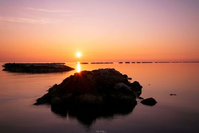 Scenic view of sea against romantic sky at sunset