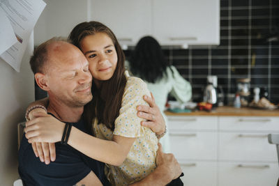 Loving father and daughter hugging at home