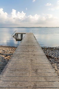 Wooden pier on sea against sky