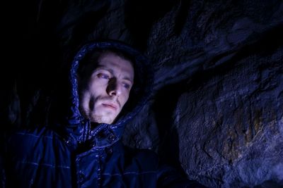 Low angle view of man by rocks at night