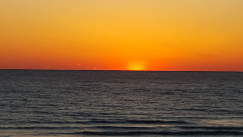 Scenic view of sea against orange sky