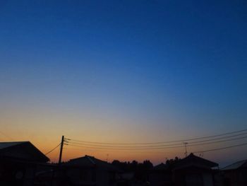 Low angle view of silhouette buildings against clear sky